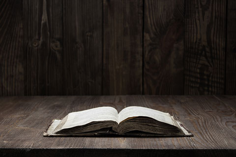 old Bible on a rough wooden surface